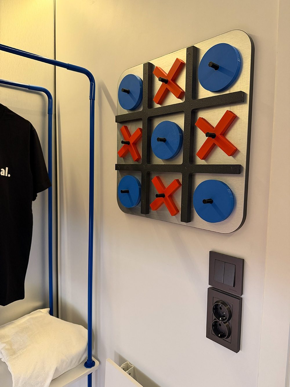 Tic-tac-toe wall panel, power sockets and clothes rail inside a SleepPod Space capsule